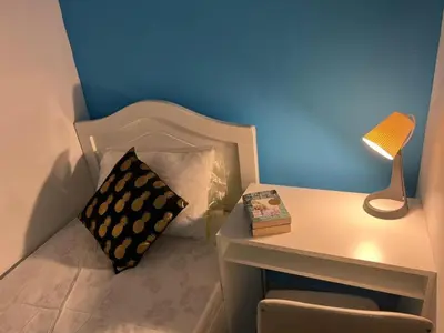a bed with a pillow and a table with a lamp at Small Partition Room Barsha Heights Tecom in Dubai