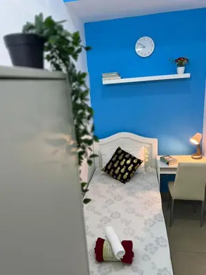 a room with a bed and a desk and a blue wall at Small Partition Room Barsha Heights Tecom in Dubai