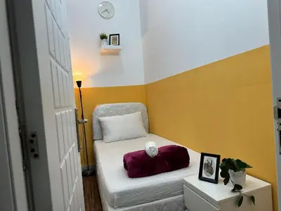 a small room with a bed and a chair at Smart Partition Room Barsha ! in Dubai