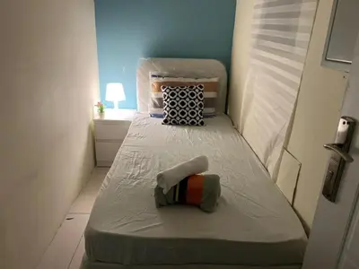 a small bedroom with two beds in a room at The Pod Partition Room Al Barsha 1 in Dubai