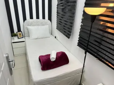 a small room with a bed with a pillow and a lamp at Beautiful Partition Room in Al Barsha 1 in Dubai