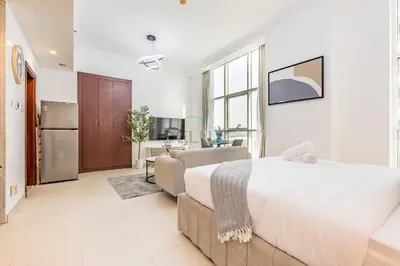 a bedroom with a large bed and a living room at Studio Near Dubai Water Canal and Bus Station, Conveniently Close to Downtown, The Scala Tower, Business Bay by Deluxe Holiday Homes in Dubai