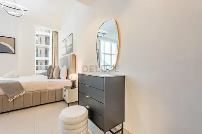a bedroom with a bed and a mirror on a dresser at Studio Near Dubai Water Canal and Bus Station, Conveniently Close to Downtown, The Scala Tower, Business Bay by Deluxe Holiday Homes in Dubai