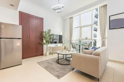 a kitchen and living room with a couch and a table at Studio Near Dubai Water Canal and Bus Station, Conveniently Close to Downtown, The Scala Tower, Business Bay by Deluxe Holiday Homes in Dubai