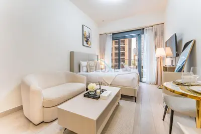 a white living room with a bed and a couch at Modern Studio Near Downtown Dubai, Few Mins Walk to Hartland Greens Park, Azizi Riviera 43, Al Merkadh by Deluxe Holiday Homes in Dubai