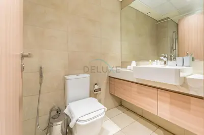 a bathroom with a toilet and a sink and a mirror at Modern Studio Near Downtown Dubai, Few Mins Walk to Hartland Greens Park, Azizi Riviera 43, Al Merkadh by Deluxe Holiday Homes in Dubai