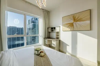 a bedroom with a bed and a large window at Luxury 2BHK in Jumeirah Lakes Towers Icon 3502 in Dubai
