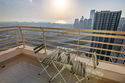a balcony with two chairs and a view of the city at Luxury 2BHK in Jumeirah Lakes Towers Icon 3502 in Dubai