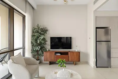 a living room with a television and a table at FIRST CLASS 2BR Creek Beach Relax in Style in Dubai