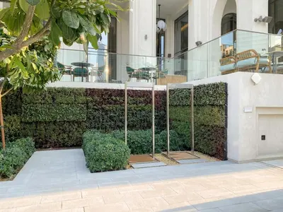 a building with a green wall with tables and chairs at FIRST CLASS 2BR Creek Beach Relax in Style in Dubai