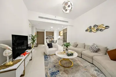 a living room with a couch and a tv at Beachfront 2BR Grand Bleu Luxe Near Dubai Palm & Marina Hotspots in Dubai