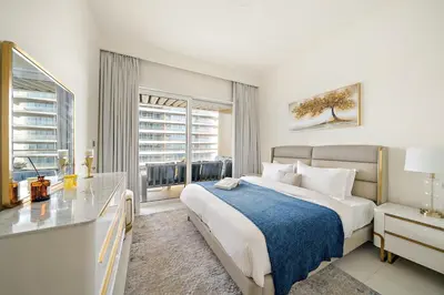 a bedroom with a large bed and a window at Beachfront 2BR Grand Bleu Luxe Near Dubai Palm & Marina Hotspots in Dubai