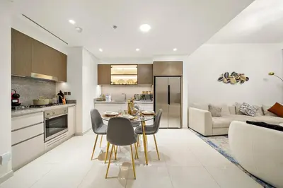 a kitchen and living room with a table and chairs at Beachfront 2BR Grand Bleu Luxe Near Dubai Palm & Marina Hotspots in Dubai