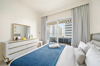 a bedroom with a bed and a mirror and a window at Beachfront 2BR Grand Bleu Luxe Near Dubai Palm & Marina Hotspots in Dubai