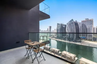 a table and chairs on a balcony with a view of a river at Apartment with Burj Khalifa, Canal View with Big Balcony in Dubai