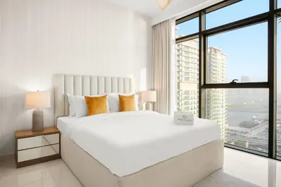 a white bedroom with a large bed and a large window at FIRST CLASS 2BR Sea & Palm View, Beachfront in Dubai