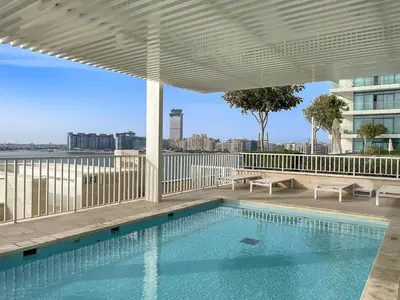 a swimming pool on the roof of a building at FIRST CLASS 2BR Sea & Palm View, Beachfront in Dubai