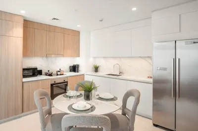 a kitchen with a table with chairs and a refrigerator at FIRST CLASS 2BR Sea & Palm View, Beachfront in Dubai