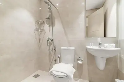 a white bathroom with a toilet and a sink at FIRST CLASS 4BR Luxe Downtown Escape in Dubai