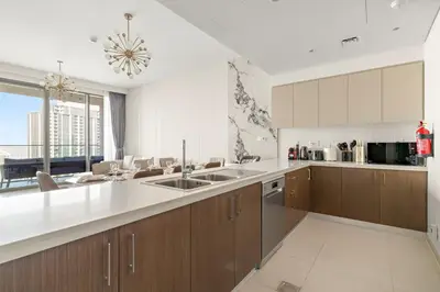 a large kitchen with wooden cabinets and a large window at FIRST CLASS 4BR Luxe Downtown Escape in Dubai