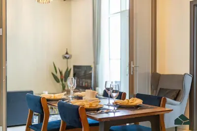 a dining room with a wooden table and chairs at Convertible 1BR with Canal and Skyline View by BMS in Dubai