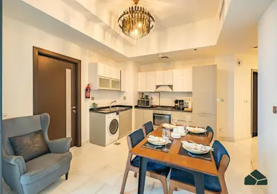a kitchen and living room with a table and chairs at Convertible 1BR with Canal and Skyline View by BMS in Dubai