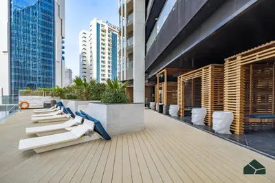 a row of white chairs on the roof of a building at Convertible 1BR with Canal and Skyline View by BMS in Dubai