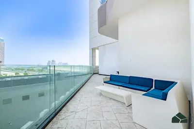 a room with a blue couch in a building at Convertible 1BR with Canal and Skyline View by BMS in Dubai