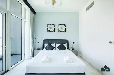 a bedroom with a white bed and a large window at Convertible 1BR with Canal and Skyline View by BMS in Dubai