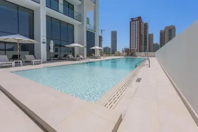 a swimming pool on the side of a building at Homes & Beyond l Serene 1BR Retreat in JVC in Dubai