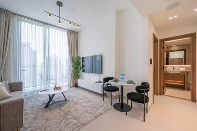 a living room with a couch and a table and chairs at Homes & Beyond l Serene 1BR Retreat in JVC in Dubai