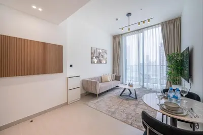 a living room with a table and a couch at Homes & Beyond l Serene 1BR Retreat in JVC in Dubai