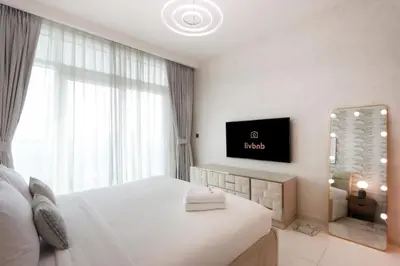 a hotel room with a bed and a television at Elegant 2BR with Dubai Marina Skyline & Sunset Views in Dubai