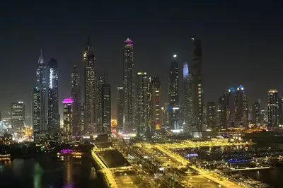 a night view of a large city with lights at Elegant 2BR with Dubai Marina Skyline & Sunset Views in Dubai
