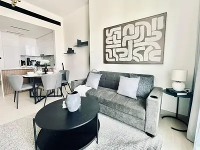 a living room with a couch and a table at Crisp And Curated 1br With Pool, Gym And Parking! in Dubai