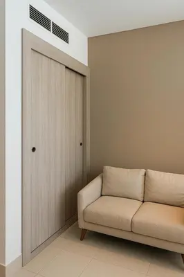 a living room with a couch and a door at Happy Dom Palm in Dubai