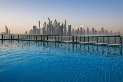 a swimming pool with a city skyline in the background at Happy Dom Palm in Dubai