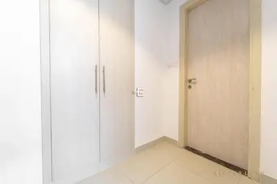 a hallway with white cabinets and a door at Perfect Midtown Studio Bright & Stylish in Dubai