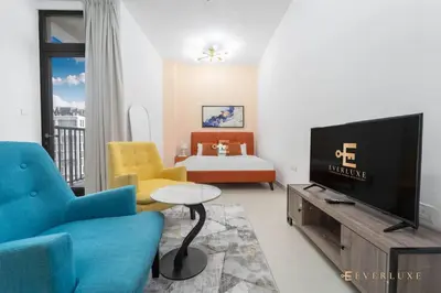 a living room with a couch and a tv at Perfect Midtown Studio Bright & Stylish in Dubai
