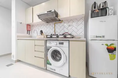 a kitchen with a washing machine and a refrigerator at Perfect Midtown Studio Bright & Stylish in Dubai