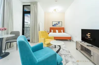 a hotel room with a bed and a tv at Perfect Midtown Studio Bright & Stylish in Dubai