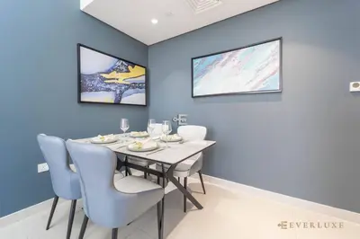 a dining room with blue walls and a table and chairs at Stylish 1br In Midtown Impz Soft Modern Vibes in Dubai