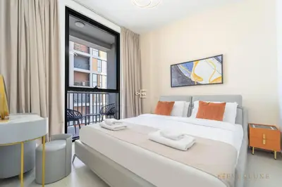 a bedroom with a large bed and a balcony at Stylish 1br In Midtown Impz Soft Modern Vibes in Dubai