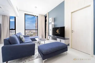 a living room with a blue couch and a tv at Stylish 1br In Midtown Impz Soft Modern Vibes in Dubai