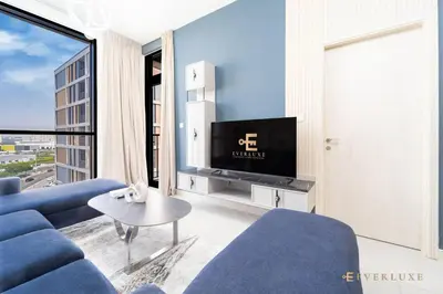 a living room with a blue couch and a tv at Stylish 1br In Midtown Impz Soft Modern Vibes in Dubai