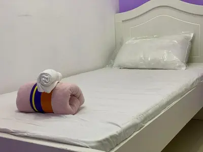 a stuffed animal is sitting on a bed at Elegant Partition Room Al Barsha 1 in Dubai