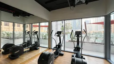 a gym with treadmills and ellipticals in a room with windows at Luxury 2,5BR Burj Khalifa Views with Pool and Gym Access Near Dubai Mall in Dubai
