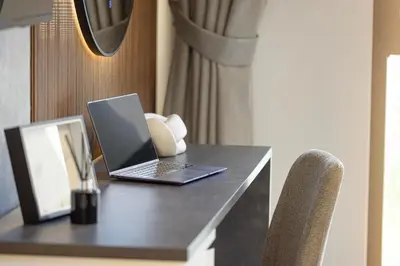 a laptop computer sitting on a desk with a chair at Elegant Stay with Pool & Gym Near Iconic Landmarks in Dubai