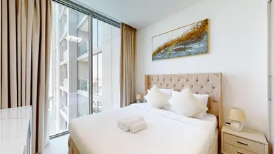 a bedroom with a white bed and a large window at Creek Vistas - Elegant One Bedroom in Meydan in Dubai