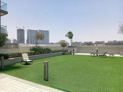 a large grassy area with chairs and benches on a building at Creek Vistas - Elegant One Bedroom in Meydan in Dubai